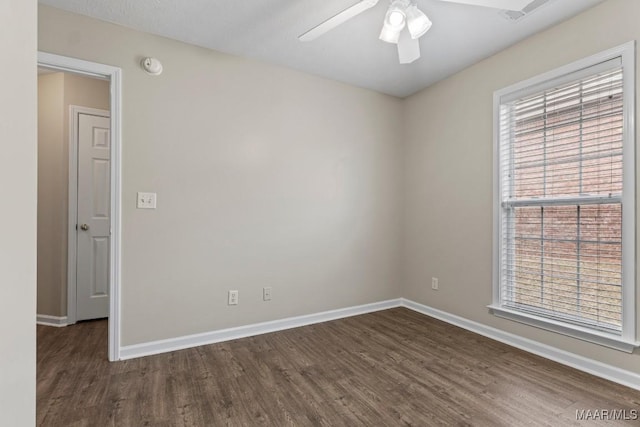 spare room featuring dark wood-type flooring and ceiling fan