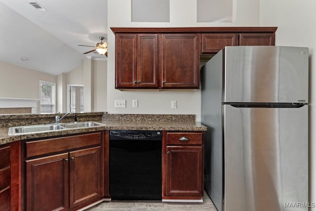 kitchen featuring lofted ceiling, sink, stainless steel fridge, black dishwasher, and ceiling fan