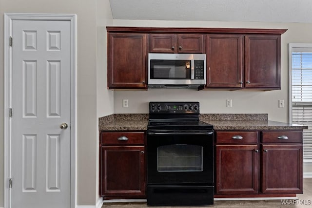 kitchen featuring dark stone counters and electric range