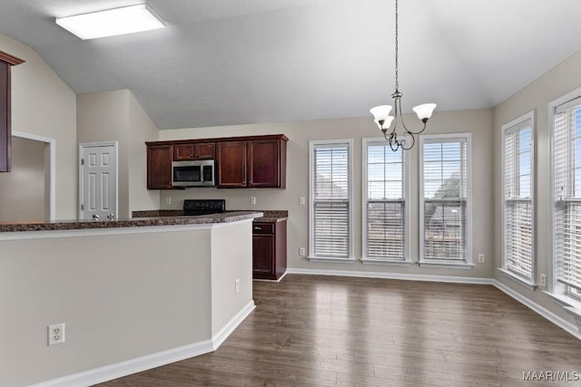 kitchen featuring lofted ceiling, dark hardwood / wood-style floors, a notable chandelier, and decorative light fixtures