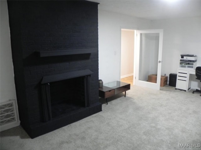 carpeted living room featuring a brick fireplace and french doors