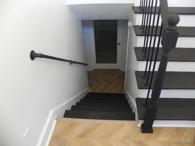 stairs featuring parquet flooring