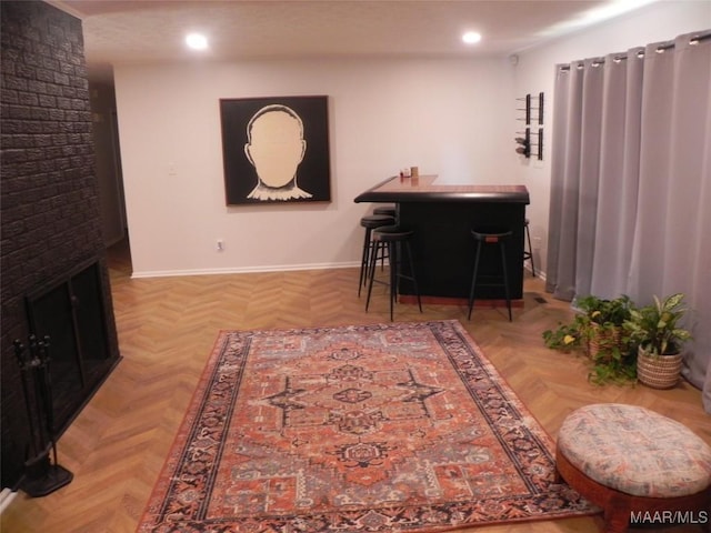 interior space with light parquet flooring and a brick fireplace