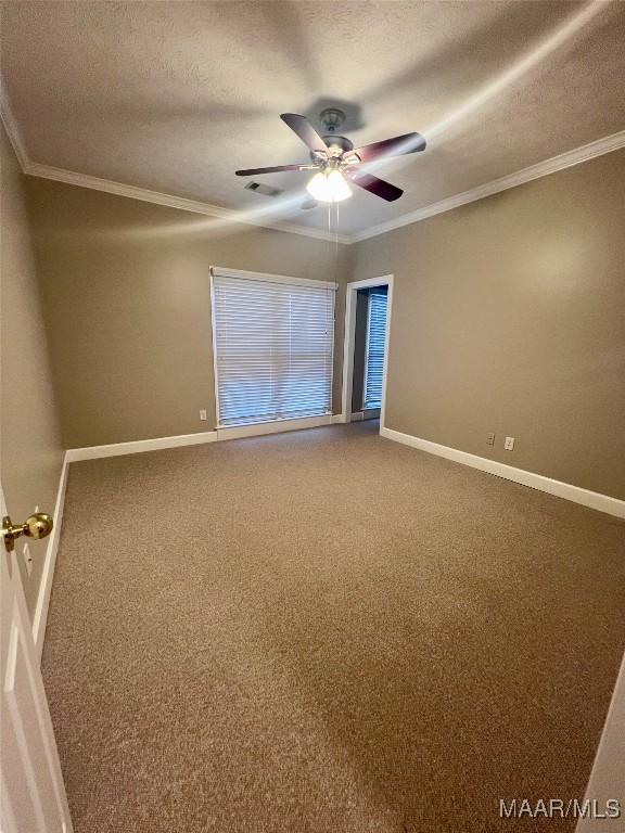 carpeted empty room featuring ceiling fan, ornamental molding, and a textured ceiling