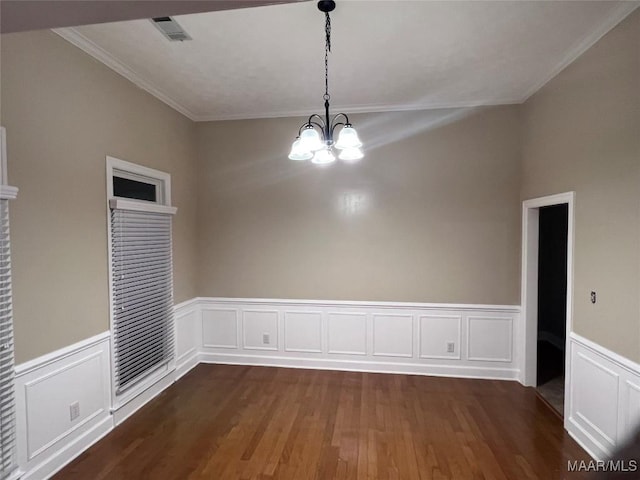 unfurnished room featuring dark hardwood / wood-style flooring, crown molding, and a chandelier