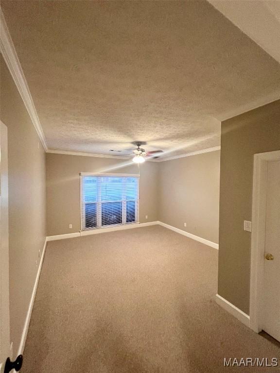 empty room with crown molding, carpet flooring, ceiling fan, and a textured ceiling