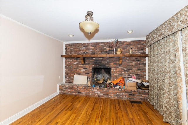 unfurnished living room featuring ornamental molding, hardwood / wood-style floors, and a fireplace