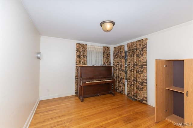 sitting room with ornamental molding, wood finished floors, and baseboards