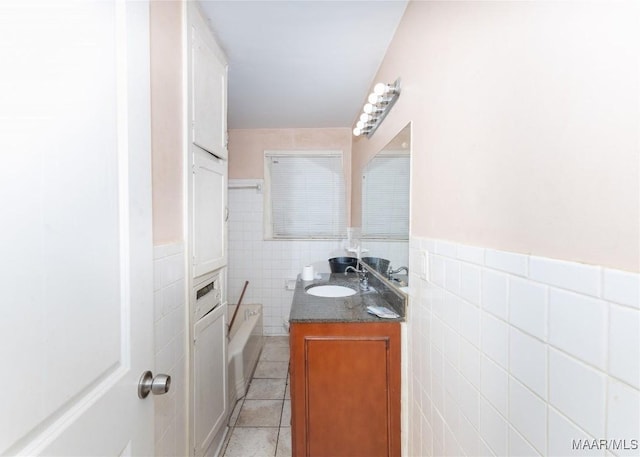 bathroom with tile walls, a wainscoted wall, tile patterned flooring, and vanity