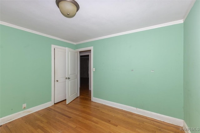 unfurnished room with wood-type flooring and ornamental molding