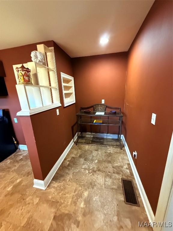 interior space with stone finish floor, visible vents, and baseboards