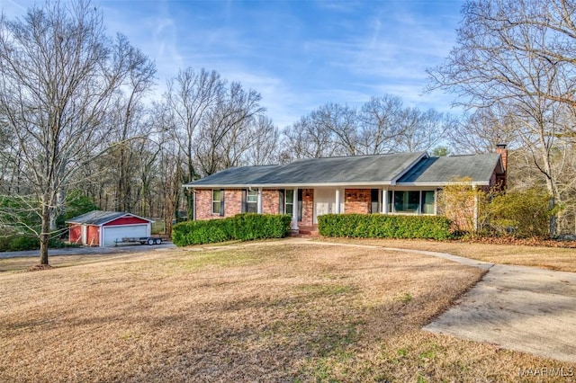 single story home featuring a garage, an outbuilding, and a front lawn