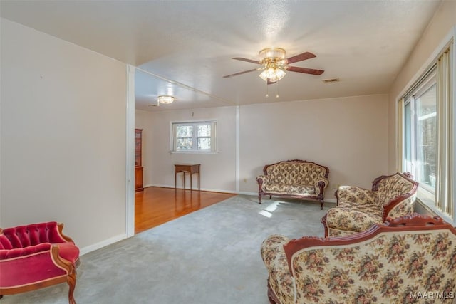 sitting room with ceiling fan and carpet floors