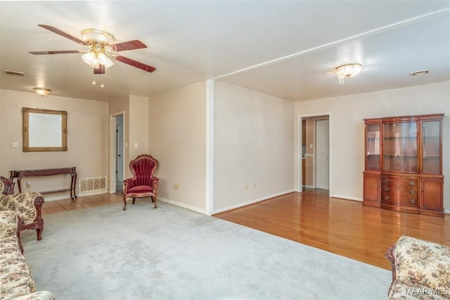 living room with ceiling fan and light hardwood / wood-style flooring