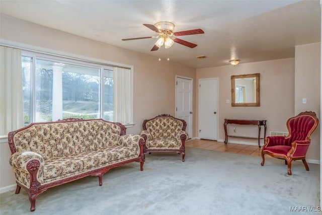 sitting room with ceiling fan and light carpet