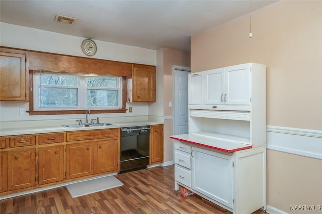 kitchen featuring white cabinetry, sink, wood-type flooring, and black dishwasher