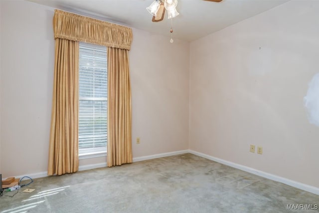 carpeted spare room featuring ceiling fan and a healthy amount of sunlight