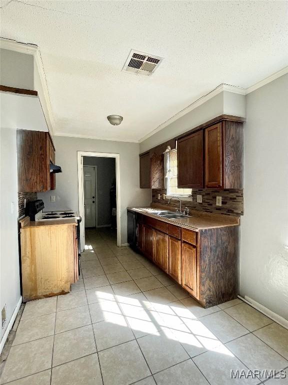 kitchen featuring ornamental molding, sink, a textured ceiling, and light tile patterned floors