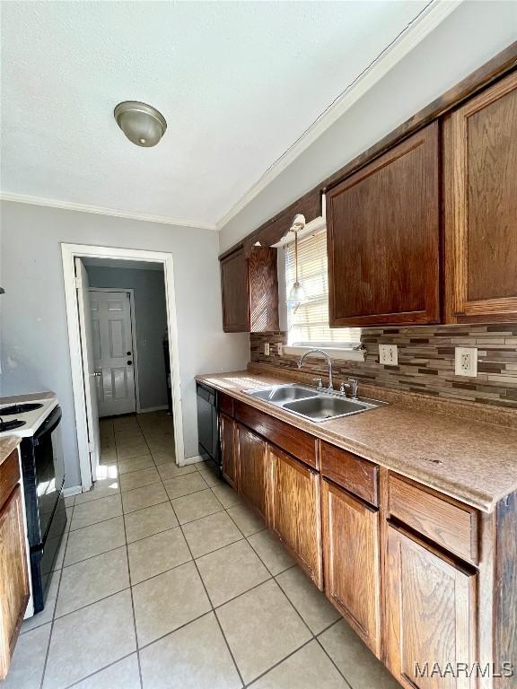 kitchen with light tile patterned flooring, sink, backsplash, electric range, and crown molding