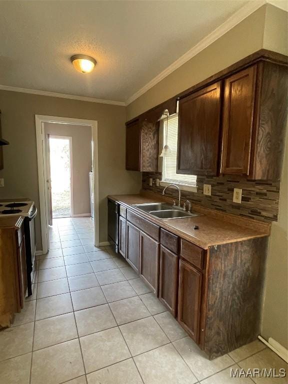 kitchen featuring dark brown cabinetry, light tile patterned floors, stove, and ornamental molding