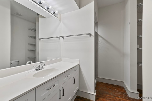 bathroom featuring vanity, hardwood / wood-style floors, and toilet