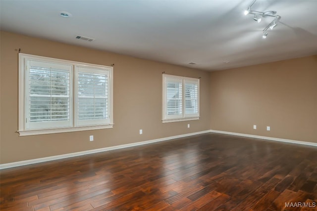 unfurnished room featuring dark hardwood / wood-style floors and track lighting