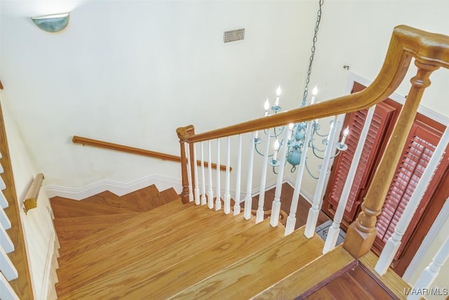 stairs featuring a notable chandelier