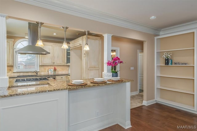 kitchen featuring decorative light fixtures, island exhaust hood, ornamental molding, light stone counters, and dark wood-type flooring