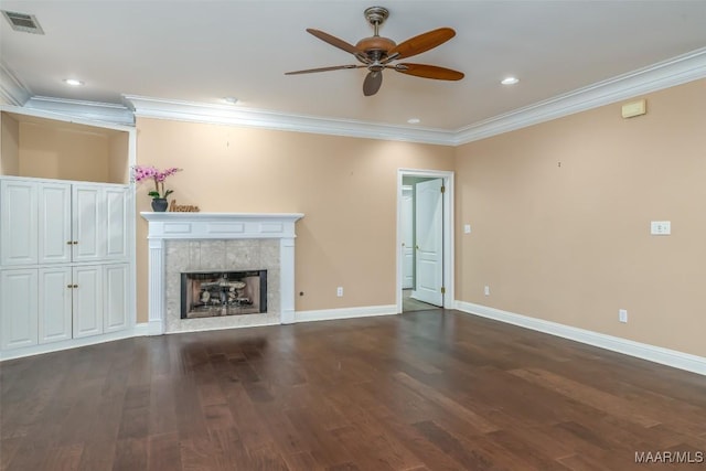 unfurnished living room featuring crown molding, ceiling fan, wood-type flooring, and a tiled fireplace