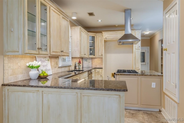 kitchen with sink, island range hood, kitchen peninsula, and dark stone counters