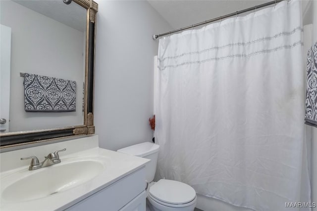 bathroom with vanity, curtained shower, and toilet