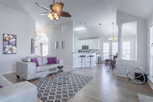 living room featuring ceiling fan with notable chandelier, hardwood / wood-style floors, and a wealth of natural light