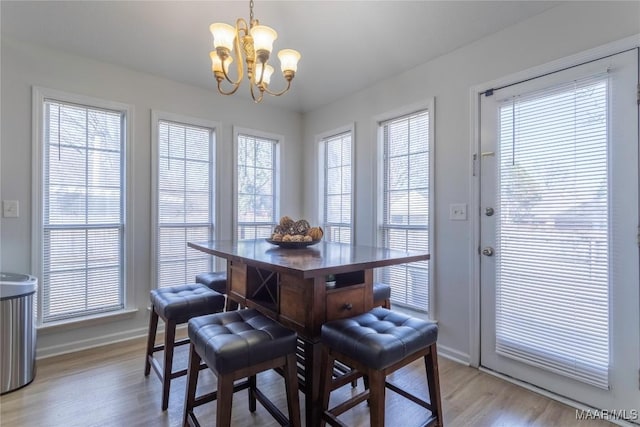 dining space with a notable chandelier and light hardwood / wood-style floors