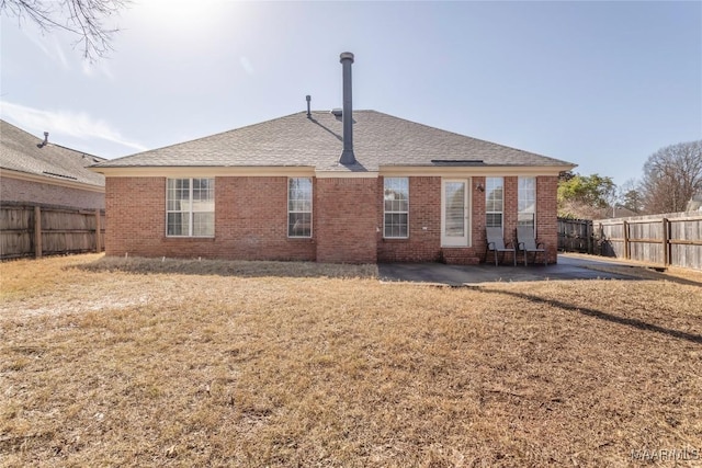 rear view of house featuring a yard and a patio area