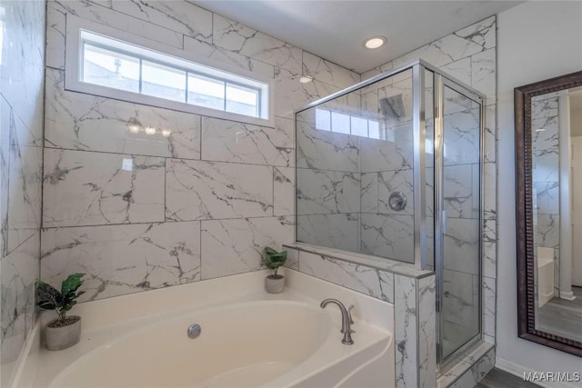 bathroom featuring separate shower and tub