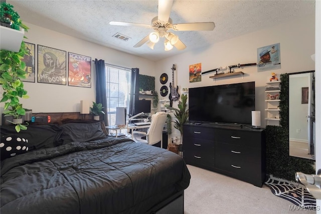 carpeted bedroom with ceiling fan and a textured ceiling