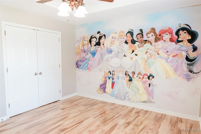 unfurnished bedroom featuring ceiling fan, hardwood / wood-style floors, and a closet