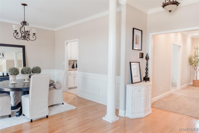 dining area with an inviting chandelier, light hardwood / wood-style flooring, ornamental molding, and decorative columns