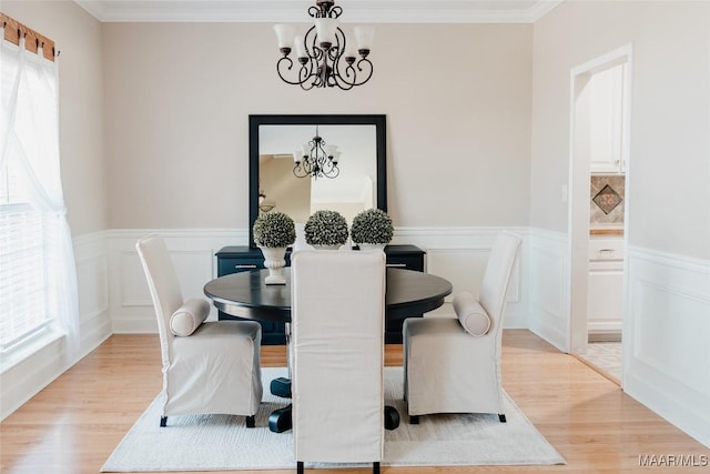 dining area with crown molding, a chandelier, and light hardwood / wood-style floors