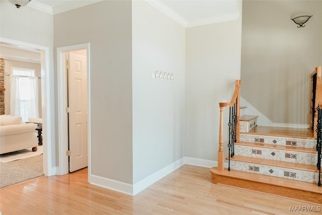 staircase featuring ornamental molding, wood finished floors, and baseboards