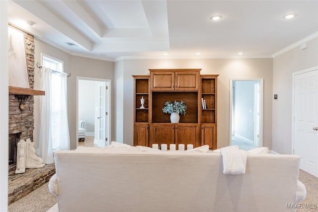 living room featuring light carpet, a stone fireplace, and crown molding