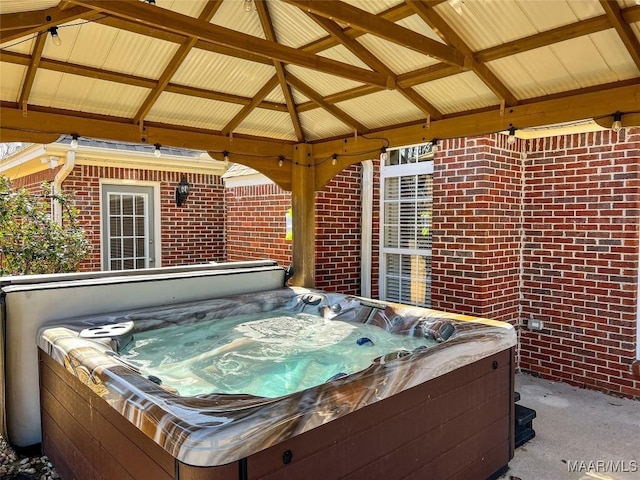 view of patio featuring a hot tub and a gazebo