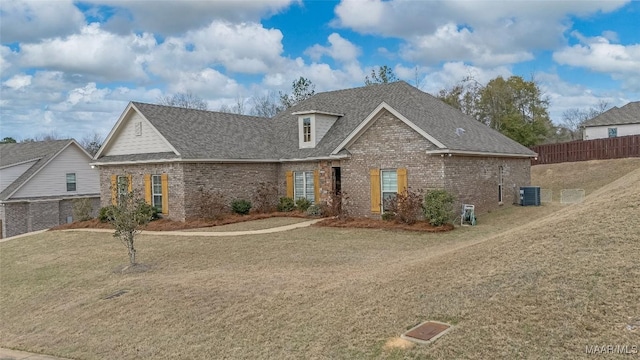 view of front of home featuring central air condition unit, brick siding, a shingled roof, fence, and a front lawn