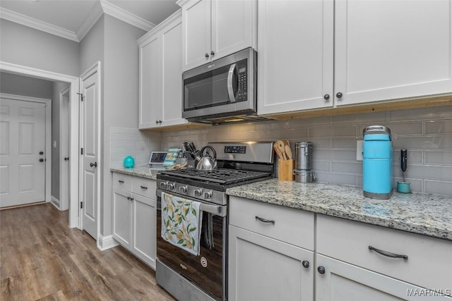 kitchen featuring crown molding, stainless steel appliances, tasteful backsplash, light wood-style flooring, and white cabinets