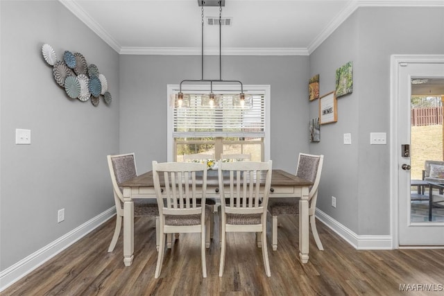 dining room with ornamental molding, visible vents, baseboards, and wood finished floors