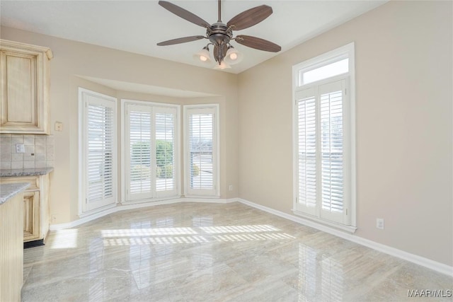 unfurnished dining area featuring a wealth of natural light and ceiling fan