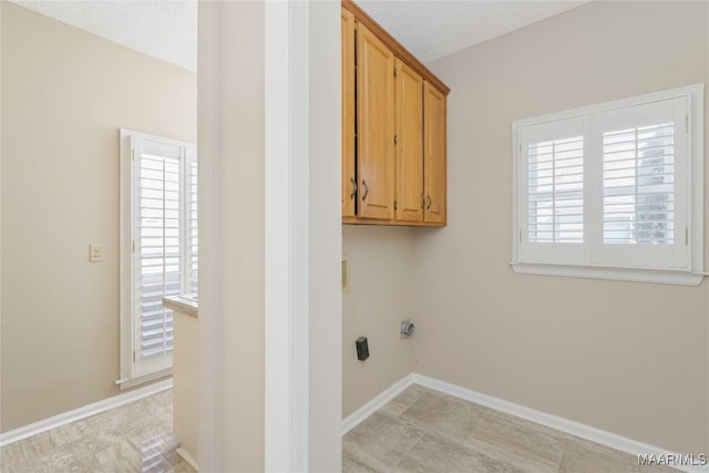 laundry area with cabinets and a textured ceiling