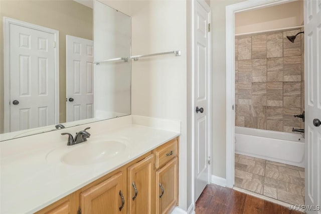 bathroom featuring tiled shower / bath combo, vanity, and hardwood / wood-style floors