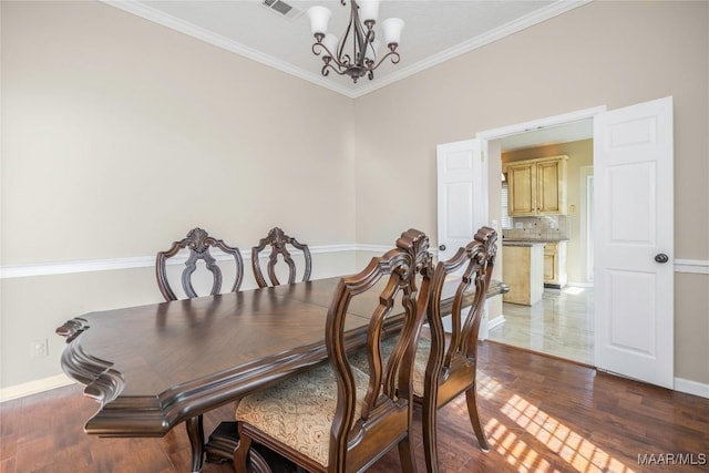 dining room featuring an inviting chandelier, ornamental molding, and wood-type flooring