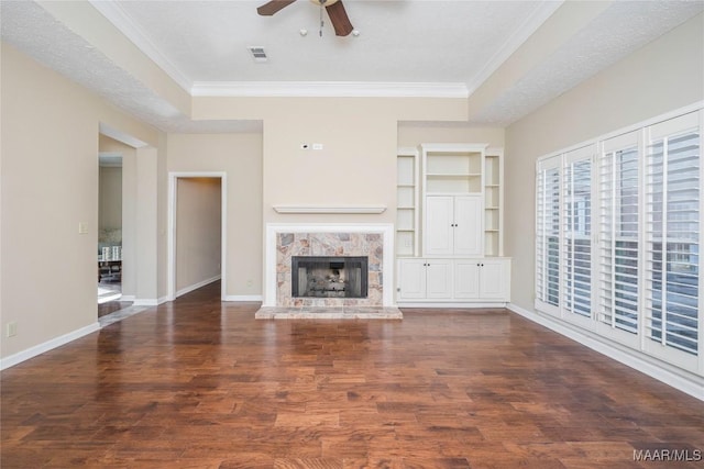 unfurnished living room featuring dark hardwood / wood-style flooring, ornamental molding, a premium fireplace, and ceiling fan